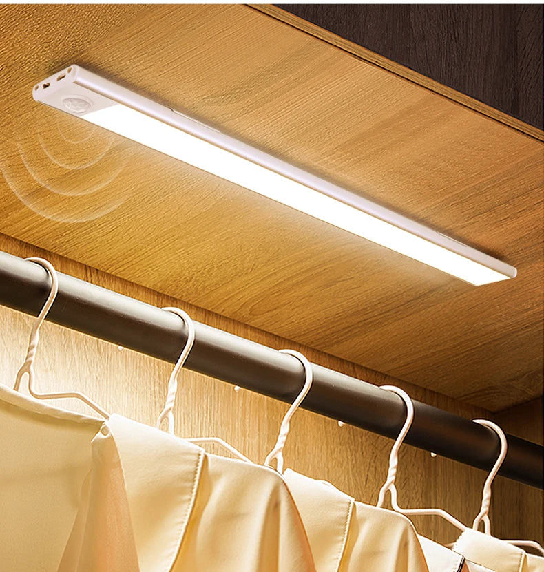 Shoppikala USB rechargeable motion sensor LED cabinet light illuminating a dark kitchen cabinet interior.